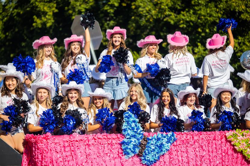 Students ride on a homecoming parade float